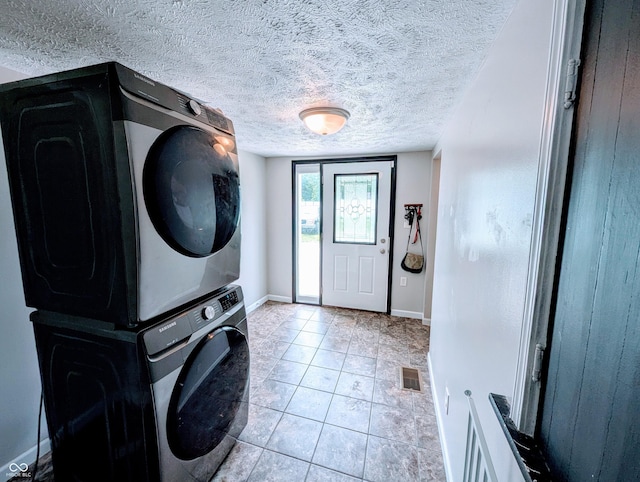 301 W Davis St, Greensburg, IN 47240 - laundry area with stacked washer / dryer, a textured ceiling, light tile patterned floors, and baseboards