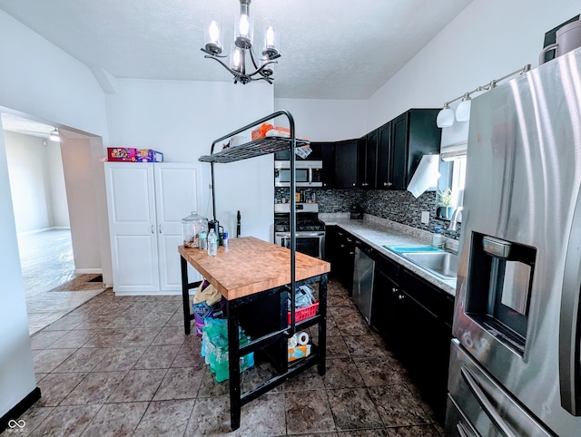 301 W Davis St, Greensburg, IN 47240 - kitchen with stainless steel appliances, dark cabinets, a sink, light countertops, and a chandelier