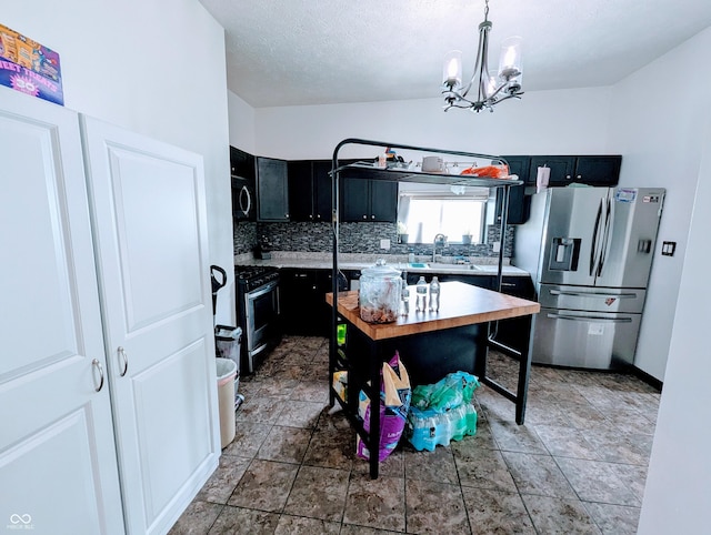 301 W Davis St, Greensburg, IN 47240 - kitchen featuring stainless steel appliances, dark cabinets, light countertops, and a chandelier