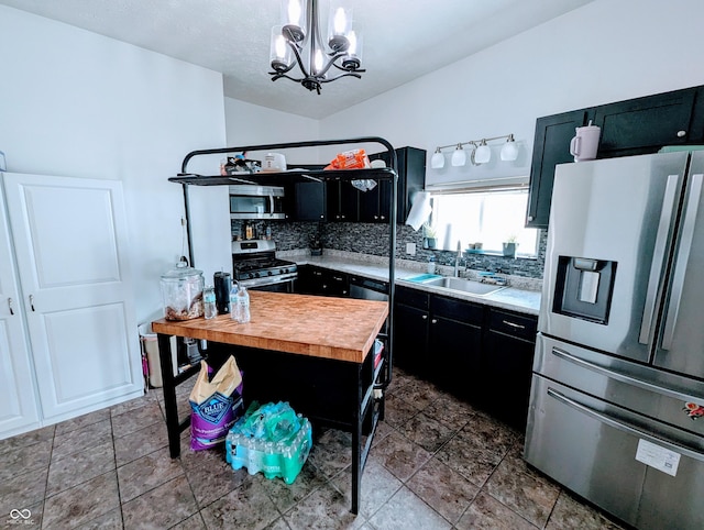 301 W Davis St, Greensburg, IN 47240 - kitchen featuring stainless steel appliances, a sink, dark cabinetry, and decorative backsplash