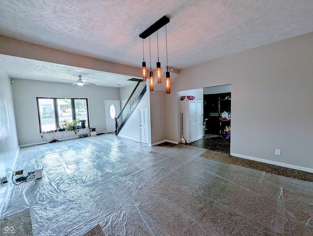 301 W Davis St, Greensburg, IN 47240 - unfurnished living room featuring a textured ceiling, baseboards, stairway, ceiling fan, and carpet