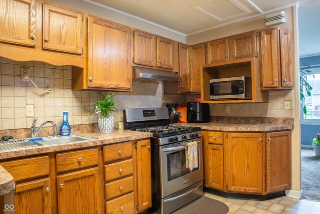 2620 13th St, Columbus, IN 47201 - kitchen featuring appliances with stainless steel finishes, under cabinet range hood, and brown cabinetry