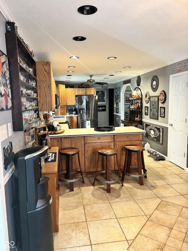 2907 Jay Dee Ln, Greenwood, IN 46143 - kitchen featuring stainless steel refrigerator with ice dispenser, open shelves, a peninsula, ornamental molding, and a breakfast bar