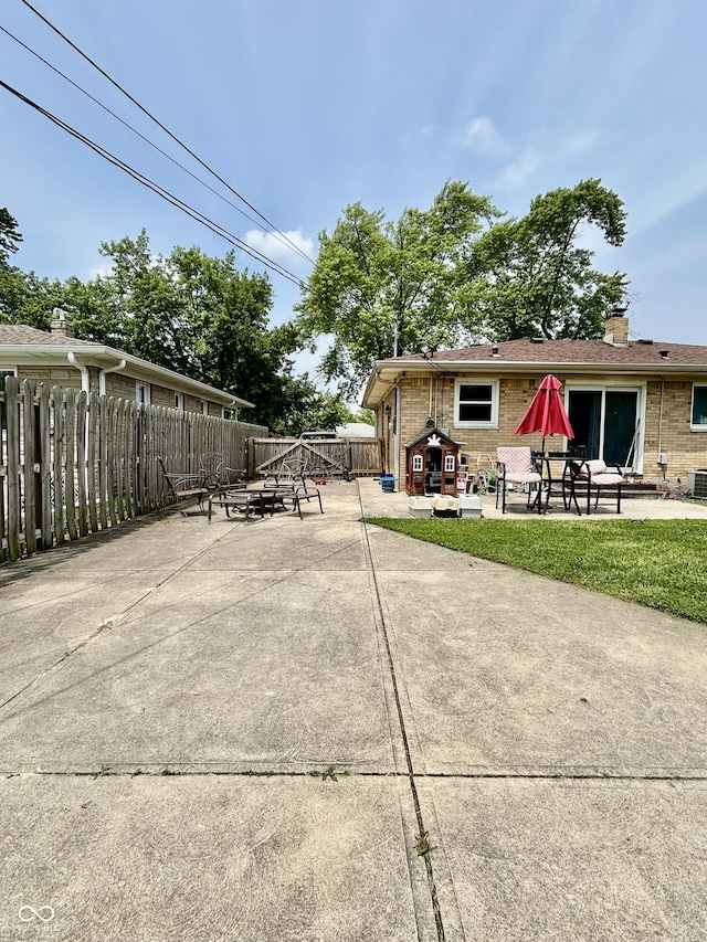 419 N 14th Ave, Beech Grove, IN 46107 - view of side of property featuring a patio area, brick siding, and a chimney