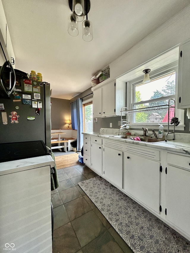 419 N 14th Ave, Beech Grove, IN 46107 - kitchen with white cabinetry, light countertops, freestanding refrigerator, and dark tile patterned flooring
