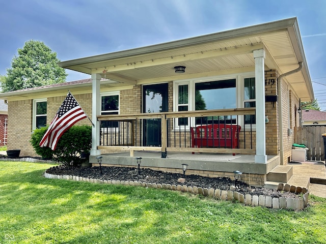 419 N 14th Ave, Beech Grove, IN 46107 - view of exterior entry with brick siding, a yard, and a porch