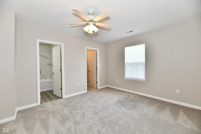 2026 Spruce St, Indianapolis, IN 46203 - unfurnished bedroom with carpet floors, baseboards, ensuite bathroom, and ceiling fan