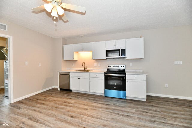 2026 Spruce St, Indianapolis, IN 46203 - kitchen with stainless steel appliances, a sink, light wood-style flooring, light countertops, and a ceiling fan