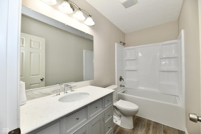 2026 Spruce St, Indianapolis, IN 46203 - bathroom with toilet, wood finished floors, vanity, and tub / shower combination