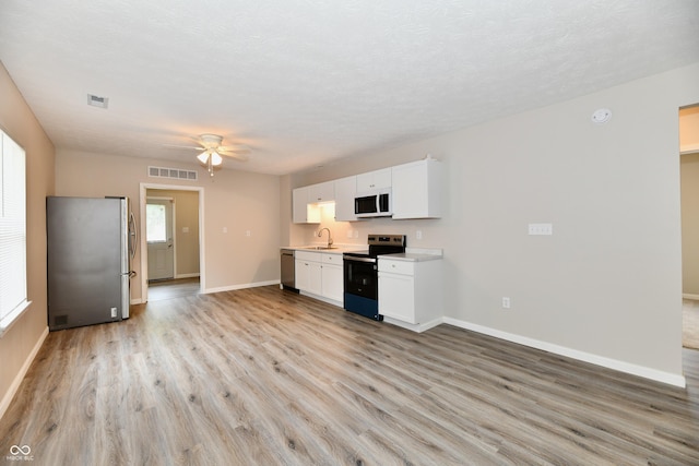 2026 Spruce St, Indianapolis, IN 46203 - kitchen featuring appliances with stainless steel finishes, a sink, light wood-style flooring, baseboards, and light countertops