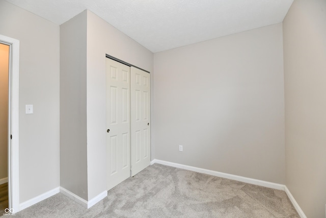 2026 Spruce St, Indianapolis, IN 46203 - unfurnished bedroom featuring light carpet, baseboards, and a closet