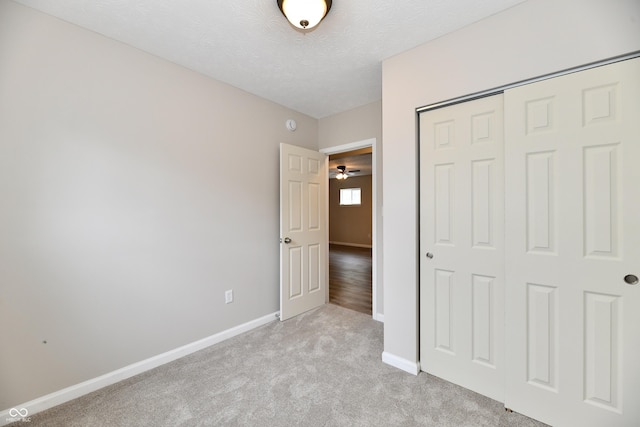 2026 Spruce St, Indianapolis, IN 46203 - unfurnished bedroom with baseboards, a closet, light carpet, and a textured ceiling