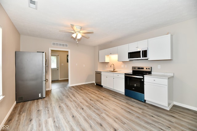 2026 Spruce St, Indianapolis, IN 46203 - kitchen with appliances with stainless steel finishes, a sink, light wood-style floors, light countertops, and ceiling fan