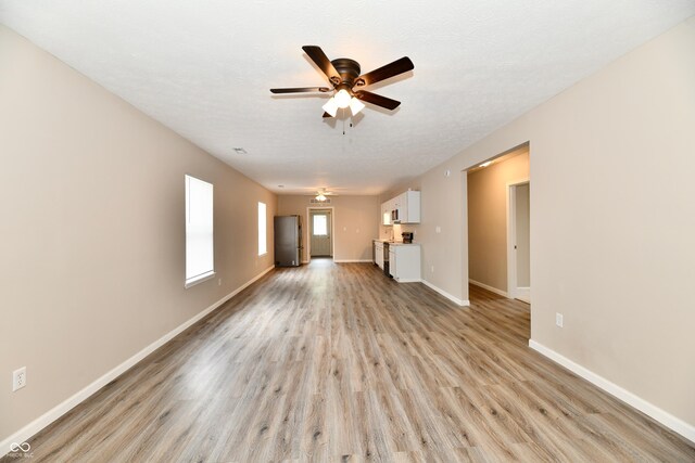 2026 Spruce St, Indianapolis, IN 46203 - unfurnished living room with a ceiling fan, light wood-style floors, and baseboards