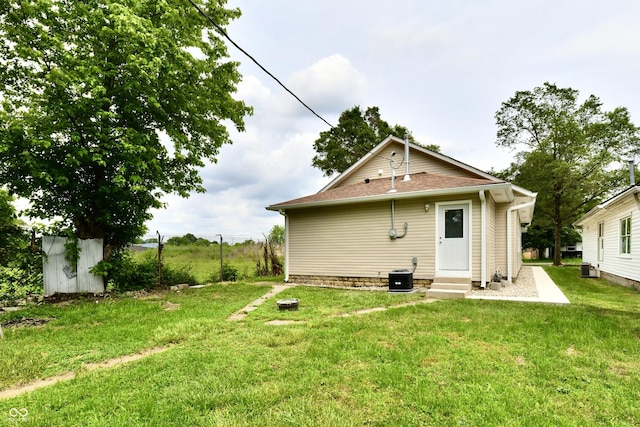 2026 Spruce St, Indianapolis, IN 46203 - rear view of property with entry steps, a yard, central AC unit, and a shingled roof