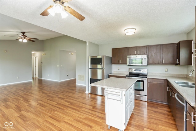 18005 Gasparilla Ct, Westfield, IN 46062 - kitchen with stainless steel appliances, a ceiling fan, a center island, open floor plan, and a textured ceiling