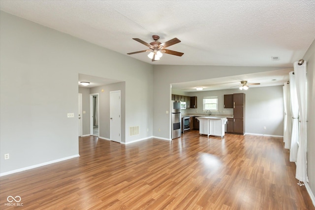 18005 Gasparilla Ct, Westfield, IN 46062 - unfurnished living room featuring a ceiling fan, light wood-style flooring, a textured ceiling, and vaulted ceiling