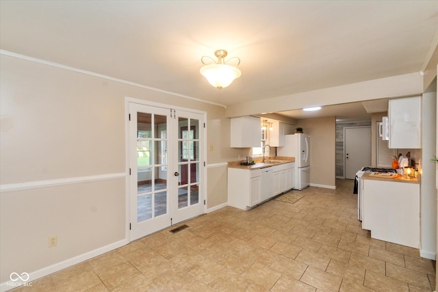 7223 Marla Dr, Indianapolis, IN 46256 - kitchen featuring white appliances, french doors, white cabinetry, light countertops, and ornamental molding