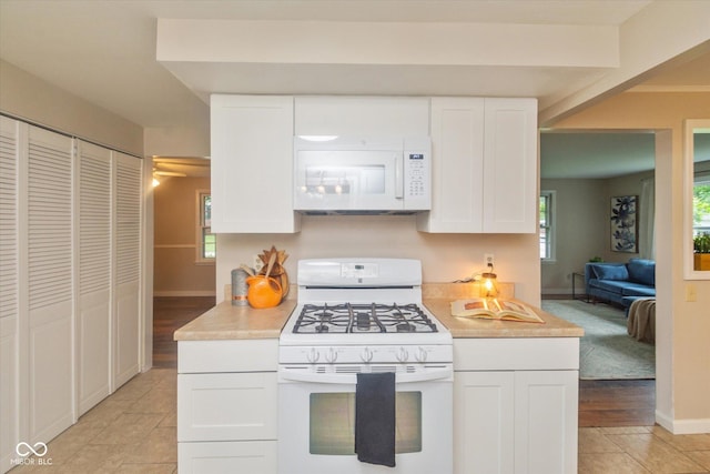 7223 Marla Dr, Indianapolis, IN 46256 - kitchen with white appliances, light countertops, white cabinetry, and light tile patterned floors