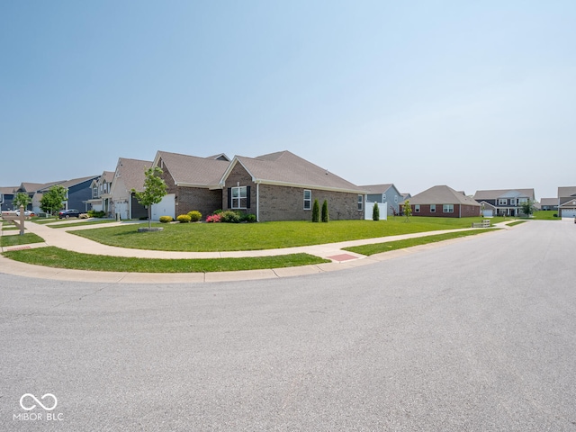 9001 Fitzgerald Dr, Indianapolis, IN 46239 - view of front of home featuring a residential view, a front lawn, an attached garage, and concrete driveway