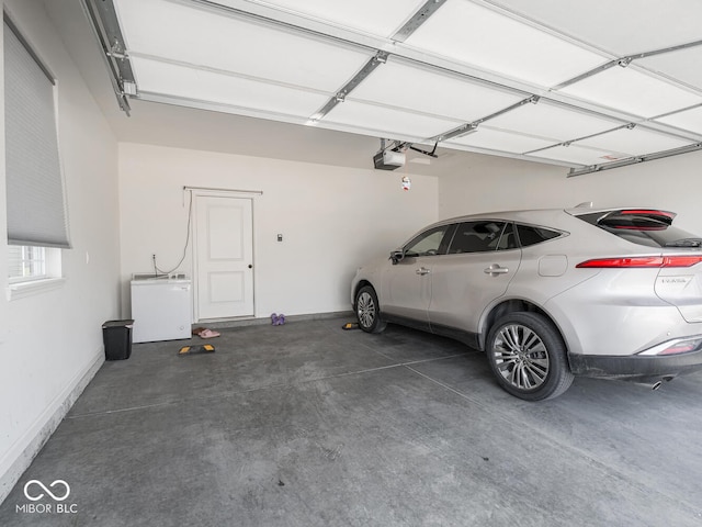 9001 Fitzgerald Dr, Indianapolis, IN 46239 - garage with a garage door opener and fridge