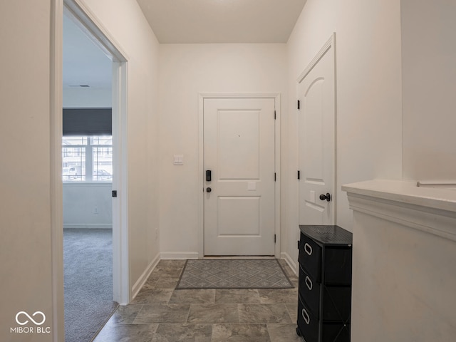 9001 Fitzgerald Dr, Indianapolis, IN 46239 - foyer entrance featuring baseboards and dark carpet