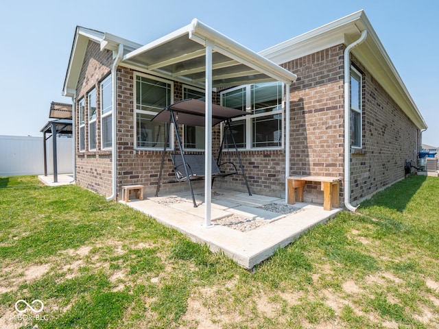 9001 Fitzgerald Dr, Indianapolis, IN 46239 - rear view of property with brick siding, a patio area, and a yard