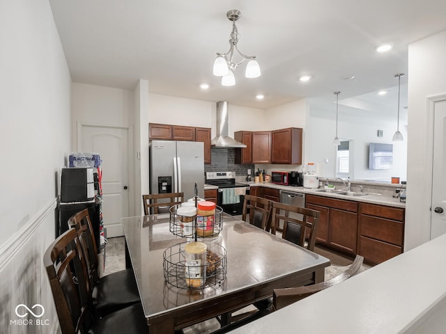 9001 Fitzgerald Dr, Indianapolis, IN 46239 - kitchen featuring wall chimney range hood, appliances with stainless steel finishes, light countertops, decorative light fixtures, and a wainscoted wall