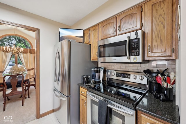 1027 Plum St Unit 39, Brownsburg, IN 46112 - kitchen with stainless steel appliances, decorative backsplash, a chandelier, and brown cabinetry