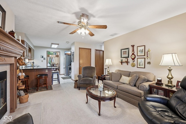 1027 Plum St Unit 39, Brownsburg, IN 46112 - living area with light carpet, a ceiling fan, and a tiled fireplace