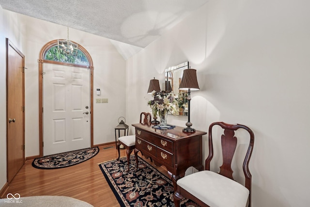 1027 Plum St Unit 39, Brownsburg, IN 46112 - foyer entrance with wood finished floors, a chandelier, lofted ceiling, and a textured ceiling