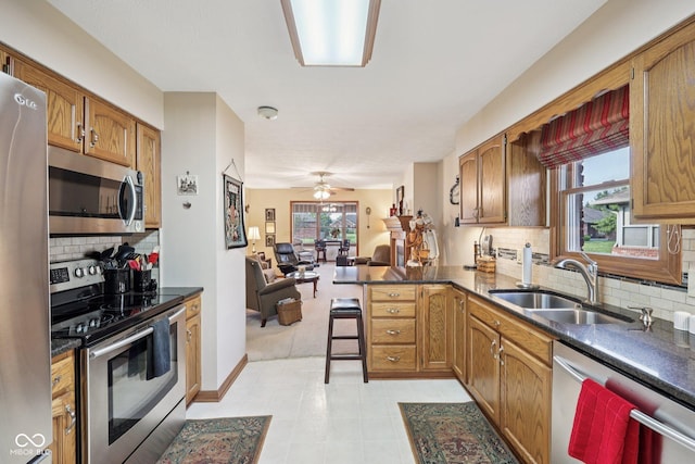 1027 Plum St Unit 39, Brownsburg, IN 46112 - kitchen featuring appliances with stainless steel finishes, open floor plan, a peninsula, dark countertops, and decorative backsplash