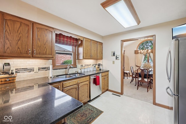 1027 Plum St Unit 39, Brownsburg, IN 46112 - kitchen with stainless steel appliances, tasteful backsplash, brown cabinetry, light carpet, and dark stone counters