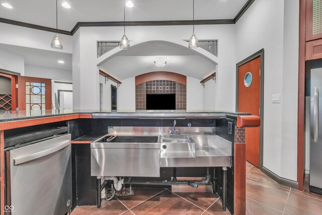 10471 Winghaven Dr, Noblesville, IN 46060 - kitchen featuring appliances with stainless steel finishes, crown molding, arched walkways, dark tile patterned flooring, and vaulted ceiling