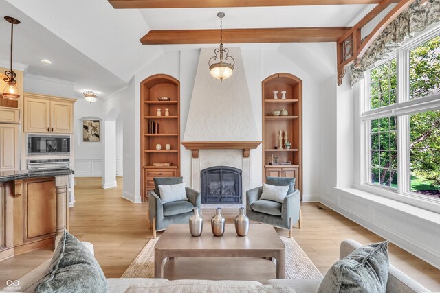 10471 Winghaven Dr, Noblesville, IN 46060 - living room with healthy amount of natural light, built in features, light wood-style floors, a glass covered fireplace, and a decorative wall