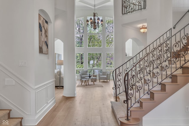 10471 Winghaven Dr, Noblesville, IN 46060 - staircase featuring a towering ceiling, a chandelier, arched walkways, crown molding, and wood-type flooring