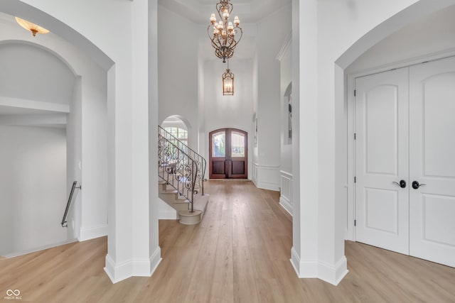 10471 Winghaven Dr, Noblesville, IN 46060 - foyer featuring arched walkways, light wood-style floors, a chandelier, and a high ceiling