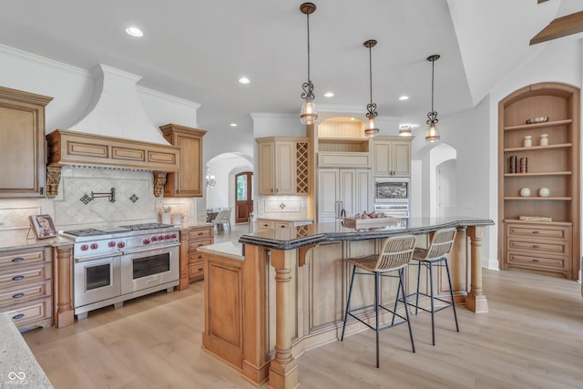 10471 Winghaven Dr, Noblesville, IN 46060 - kitchen with arched walkways, built in appliances, custom range hood, light wood-style flooring, and recessed lighting