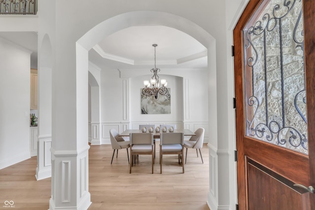 10471 Winghaven Dr, Noblesville, IN 46060 - foyer entrance featuring arched walkways, a decorative wall, light wood finished floors, a chandelier, and a raised ceiling