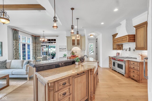 10471 Winghaven Dr, Noblesville, IN 46060 - kitchen featuring double oven range, wall chimney range hood, tasteful backsplash, light stone counters, and light wood-style flooring