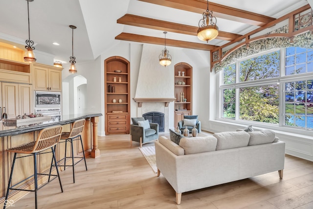 10471 Winghaven Dr, Noblesville, IN 46060 - living room featuring arched walkways, a fireplace, light wood-style flooring, and built in shelves