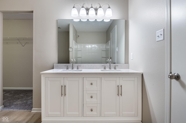 3351 Summer Breeze Cir, Indianapolis, IN 46239 - bathroom featuring wood finished floors, double vanity, a shower, and a walk in closet