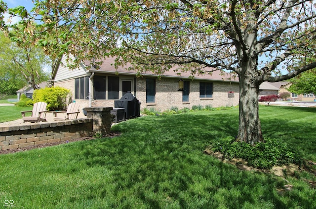 421 Kingsway Ct, Mooresville, IN 46158 - rear view of house with brick siding, a sunroom, and a lawn