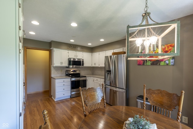 421 Kingsway Ct, Mooresville, IN 46158 - kitchen with appliances with stainless steel finishes, a chandelier, light countertops, wood finished floors, and white cabinetry