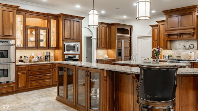 13346 W Sherbern Dr, Carmel, IN 46032 - kitchen with built in appliances, decorative backsplash, brown cabinetry, hanging light fixtures, and ornamental molding