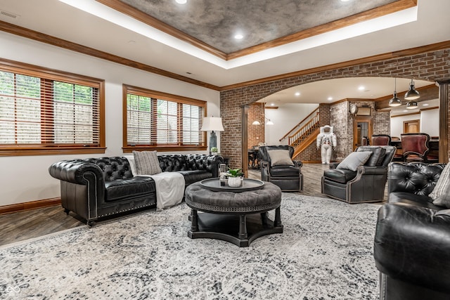 13346 W Sherbern Dr, Carmel, IN 46032 - living room with a tray ceiling, arched walkways, wood finished floors, ornate columns, and stairway