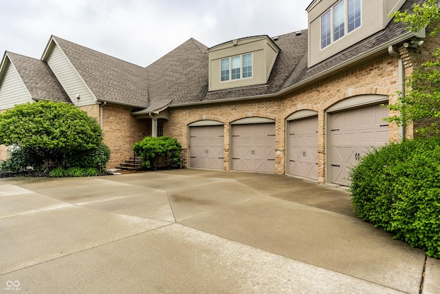 13346 W Sherbern Dr, Carmel, IN 46032 - view of front of property featuring roof with shingles, an attached garage, brick siding, and concrete driveway