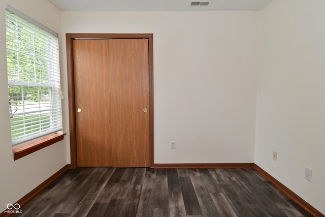 1411 Mimosa Ct, Greenfield, IN 46140 - unfurnished bedroom with dark wood-style flooring, multiple windows, and a closet