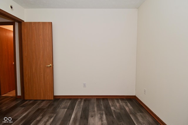1411 Mimosa Ct, Greenfield, IN 46140 - spare room featuring dark wood-type flooring and baseboards