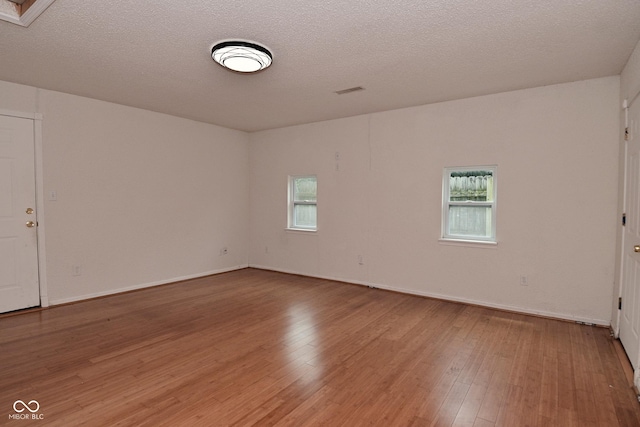 1411 Mimosa Ct, Greenfield, IN 46140 - unfurnished room with healthy amount of natural light, wood finished floors, and a textured ceiling